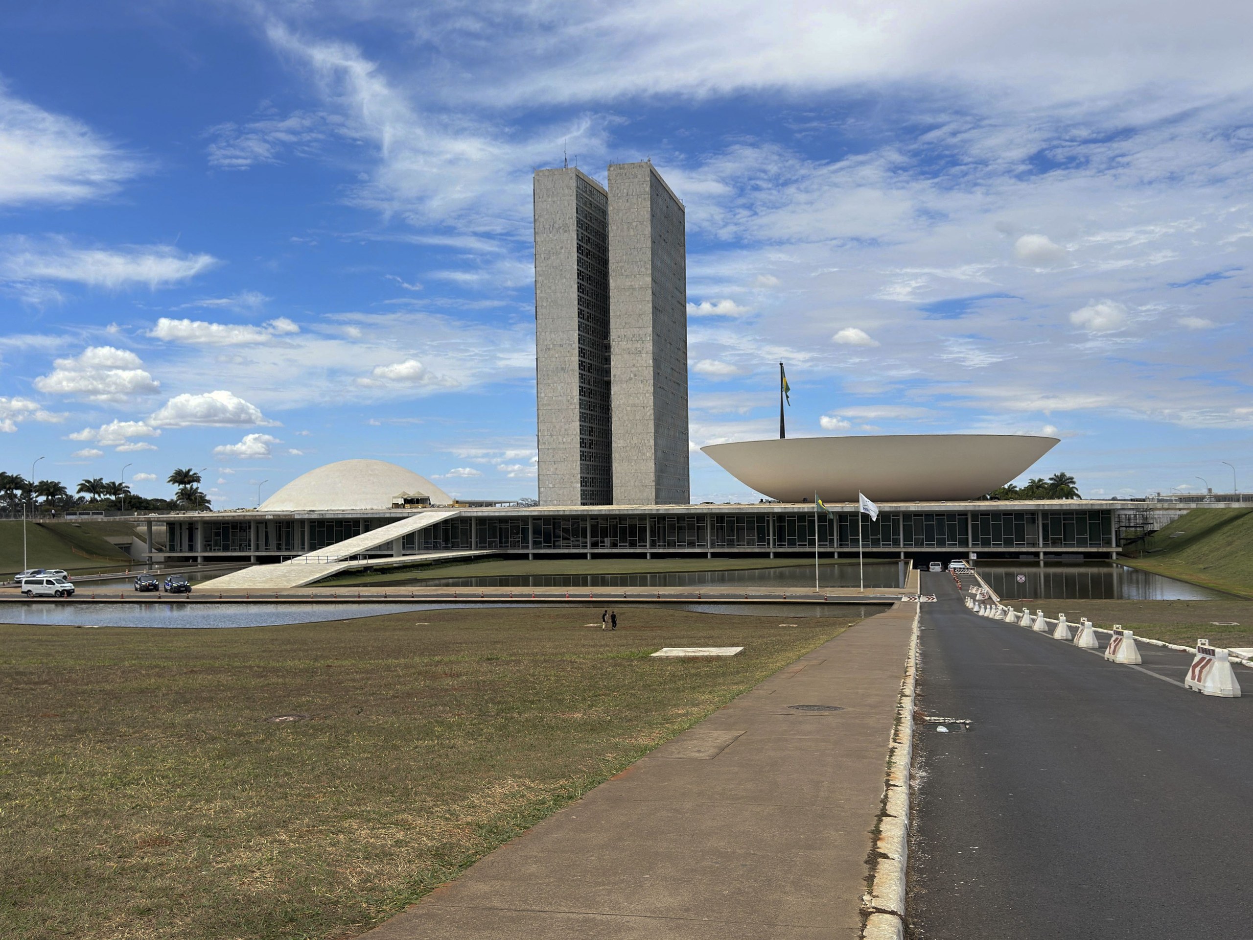 Vista panorâmica do Congresso Nacional em Brasília sob um céu azul com nuvens.