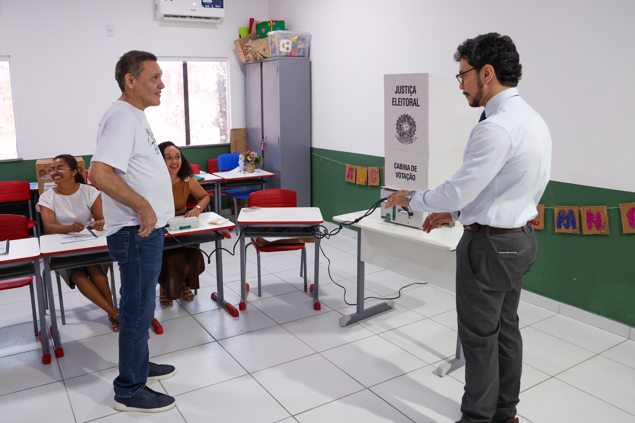 Um servidor da Justiça Eleitoral demonstra o funcionamento de uma urna eletrônica em uma sala de aula.