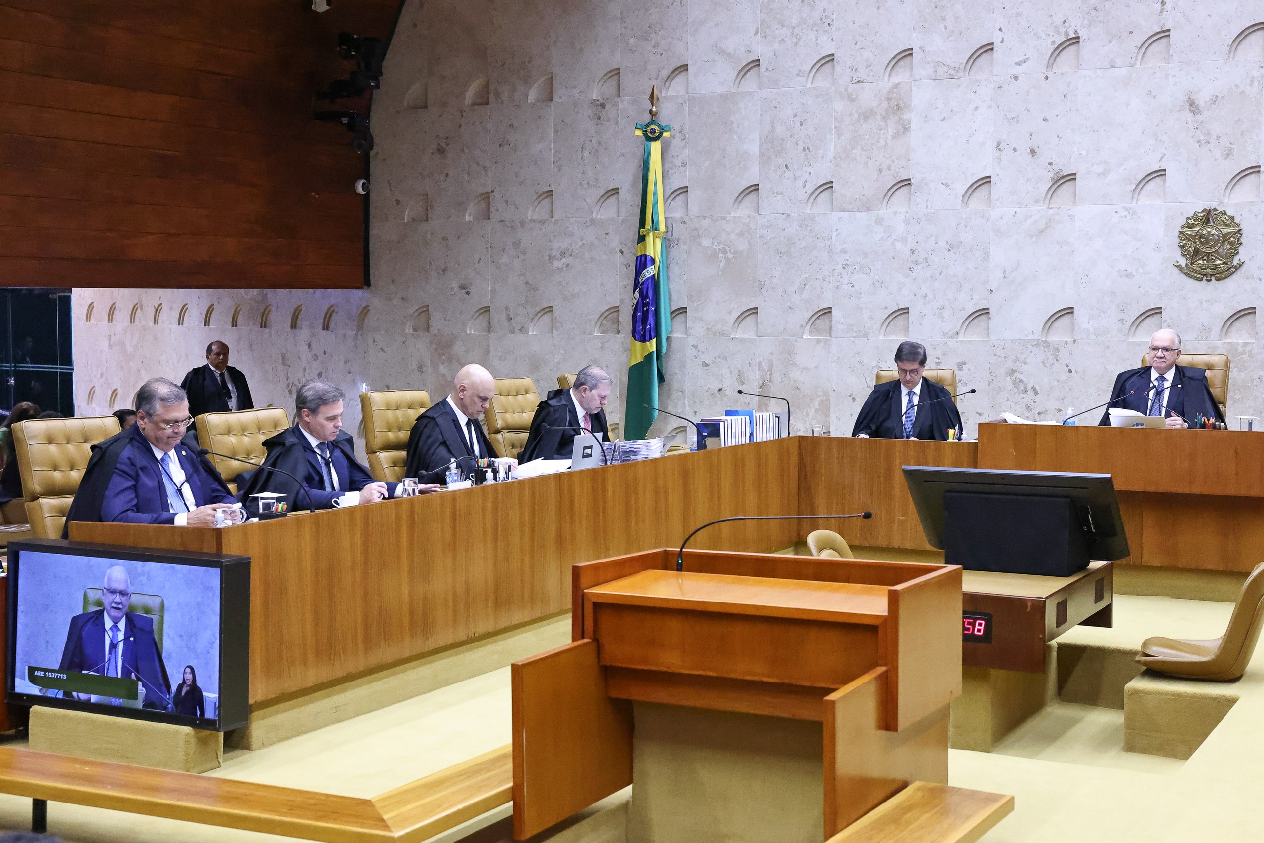 Autoridades sentadas à mesa de um tribunal ou órgão governamental brasileiro durante uma sessão oficial.