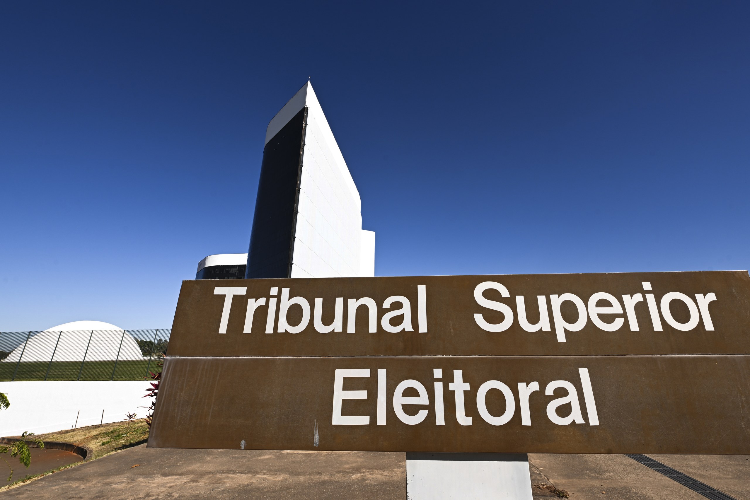 Fachada do Tribunal Superior Eleitoral (TSE) com placa de identificação em destaque sob céu azul.