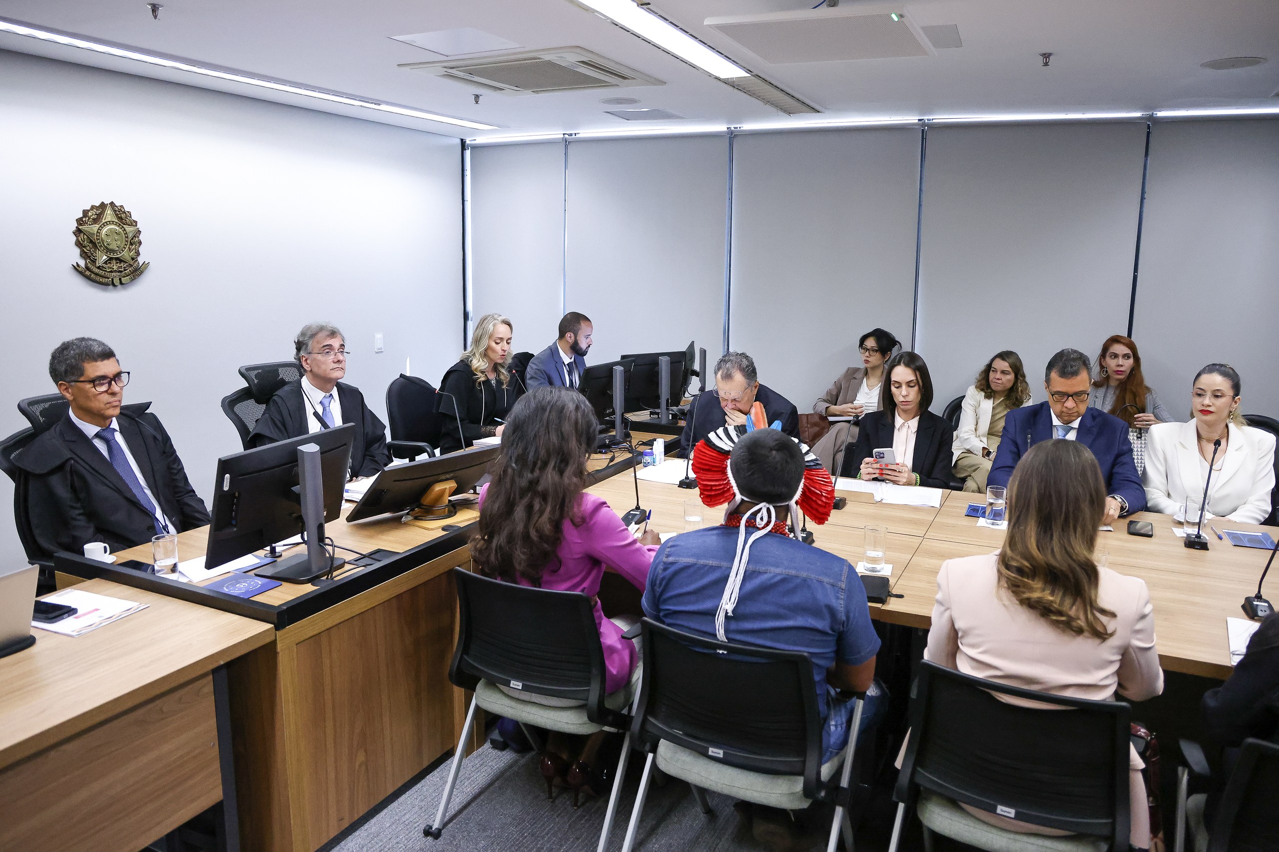 Grupo de profissionais do direito e partes interessadas durante uma audiência em um tribunal.